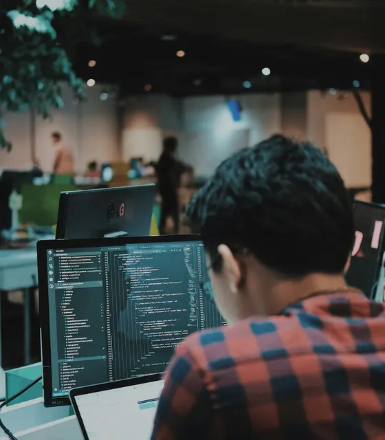 A student writing code at a computer in a modern lab
